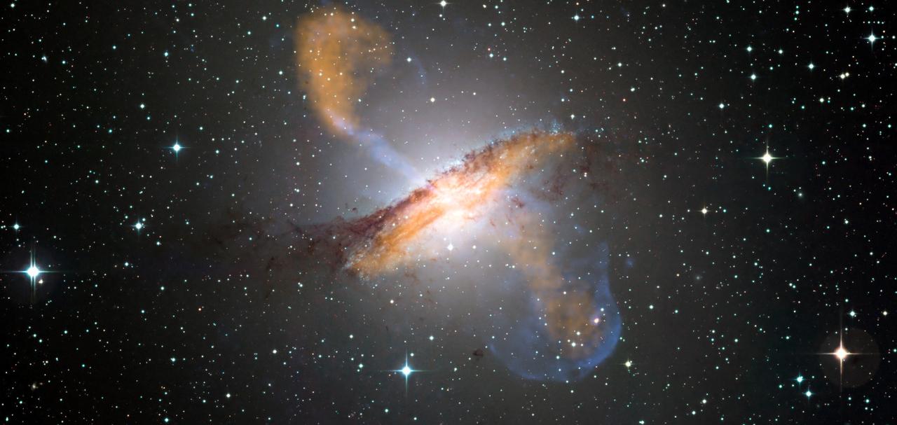 Image composite en couleurs de la galaxie Centaurus A, révélant les lobes et les jets émanant du trou noir en son centre. © ESO/WFI (Optical); MPIfR/ESO/APEX/A.Weiss et al. (Submillimetre); NASA/CXC/CfA/R.Kraft et al. (X-ray), CC BY