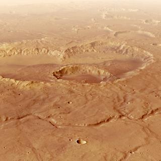 Au premier plan se trouve le tracé ramifié de la vallée Evros Vallis, au sud du cratère Schiaparelli, dont les plaines sont visibles à l'arrière-plan, dans le tiers supérieur de l'image. Evros Vallis s'étend sur environ 350 kilomètres à travers les anciennes hautes terres de Noachis Terra. Elle témoigne d'une époque, il y a plus de trois milliards et demi d'années, où Mars devait encore connaître un cycle de l'eau – avec des nuages, des précipitations, un ruissellement de surface, des rivières et des lacs, l'eau s'évaporant pour retomber ensuite sous forme de pluie. Les sédiments transportés par Evros Vallis ont probablement contribué au comblement du bassin Schiaparelli, qui atteignait autrefois une profondeur de plus de quatre kilomètres. ©&nbsp;ESA, DLR, FU Berlin, CC BY-SA 3.0 IGO