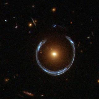 Qu'est-ce qui est grand et bleu et peut entourer une galaxie entière&nbsp;? Un mirage de lentille gravitationnelle. Sur la photo ci-dessus, la gravité d'une galaxie rouge lumineuse (LRG) a déformé gravitationnellement la lumière provenant d'une galaxie bleue beaucoup plus lointaine. Plus généralement, une telle courbure de la lumière produit deux images distinctes de la galaxie lointaine, mais ici, l'alignement des lentilles est si précis que la galaxie d'arrière-plan est déformée en un fer à cheval – un anneau presque complet. Comme un tel effet de lentille avait été généralement prédit avec assez de détails par Albert Einstein il y a plus de 70 ans, des anneaux comme celui-ci sont désormais appelés anneaux d'Einstein. Bien que LRG 3-757 ait été découverte en 2007 grâce aux données du Sloan Digital Sky Survey (SDSS), l'image ci-dessus est une observation complémentaire prise avec la caméra grand champ 3 du télescope spatial Hubble. Les lentilles gravitationnelles fortes, comme LRG 3-757, sont plus que de simples curiosités&nbsp;: leurs multiples propriétés permettent aux astronomes de déterminer la masse et la teneur en matière noire des lentilles galactiques du premier plan. © APOD