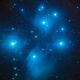 Cette image montre&nbsp;l'amas des Pléiades qui contient notamment&nbsp;Alcyone (presque au centre de cette image) qui avec des compagnons forme une étoile multiple quadruple située dans la constellation du Taureau, la plus brillante étoile de l'amas, à environ 440 années-lumière du Système solaire. ©&nbsp;Nasa, ESA, AURA Caltech, Palomar Observatory
