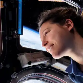 Sophie Adenot regardant la Terre dans la cuppola de la Station spatiale. © Nasa