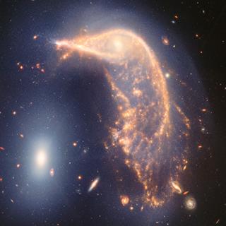 La galaxie spirale déformée au centre, le Pingouin, et la galaxie elliptique compacte à gauche, l'Œuf, sont visibles sur cette image en fausses couleurs prises dans l'infrarouge proche et moyen, combinant les données de la NIRCam (caméra proche infrarouge) et du Miri (instrument infrarouge moyen) du télescope spatial James-Webb de la Nasa. © Nasa, ESA, ASC, STScI