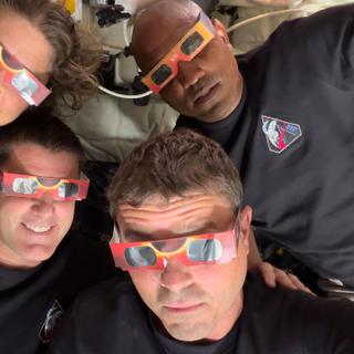 Os quatro astronautas da missão Artemis II usam óculos para assistir a um eclipse solar. © NASA