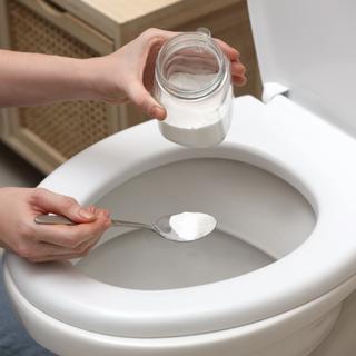 Le bicarbonate de soude associé au vinaigre blanc peut s'avérer efficace pour déboucher des toilettes. ©New Africa, Adobe Stock
