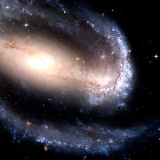 NGC 1300, uma galáxia espiral barrada. Nesta imagem do Telescópio Espacial Hubble obtida em 2005, podemos observar a galáxia espiral barrada NGC 1300. Este tipo de galáxia corresponde a galáxias espirais cujos braços espirais não emergem do centro da galáxia mas sim de uma barra constituída por estrelas que atravessam este centro. Os astrónomos acreditam que dois terços das galáxias espirais são barradas. NGC 1300 está localizada a aproximadamente 61 milhões de anos-luz da Terra, na constelação de Eridanus. Foi descoberta por John Herschel em 1835. A análise dos dados sugere que se trata de uma galáxia jovem. Constelação de Eridano. © NASA, Esa, Hubble Heritage Team, Wikimedia Commons, DP