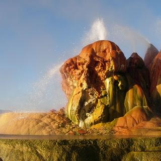 Le Fly Geyser dans le Nevada, aux États-Unis. Le Fly Geyser, aussi connu comme le Fly Ranch Geyser, se trouve dans le désert de Black Rock, au Nevada (États-Unis). Ce geyser n’est pas vraiment naturel. Il est apparu vers 1964 suite au forage d’un puits cinquante ans auparavant. Le puits n’ayant pas été correctement façonné, une source géothermique s’est infiltrée et les minéraux dissous se sont peu à peu empilés pour former ce monticule composé de trois cônes de couleur rouge orange qui crachent de l’eau en permanence. © Ken Lund, CC by-sa 2.0