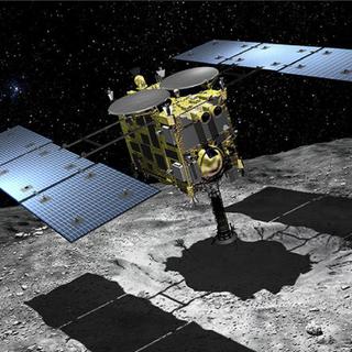 Vue d'artiste de la sonde Hayabusa-2 lors de sa deuxième tentative de prise d'échantillons en juillet 2019, près d'un cratère artificiel formé sur l'astéroïde Ryugu en avril. © Akihiro Ikeshit, Jaxa