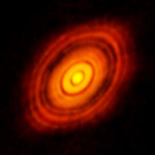 Sur cette image la plus précise jamais réalisée avec Alma, on distingue le disque protoplanétaire qui entoure la jeune étoile HL-Tauri, distante de 450 années-lumière. Ces nouvelles observations révèlent des structures dans le disque jamais observé auparavant et dévoilent même les emplacements possibles des planètes en formation dans les zones sombres au cœur du système. © Alma, Eso, NAOJ, NRAO